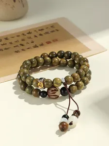 Detailed view of green sandalwood double-layered bracelet with engraved metal bead