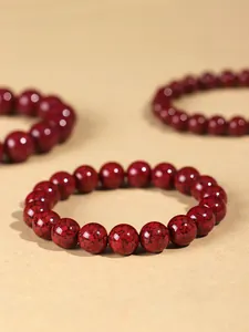 Makroaufnahme eines natürlichen roten Zinnober-Perlenarmbands mit Kristalltextur.