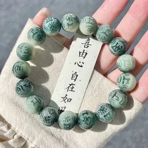 Detailed view of deep green Bodhi beads engraved with the sacred Six-Syllable Mantra
