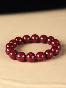 Makro-Detail des natürlichen roten Zinnoberperlenarmbands mit kristalliner Textur