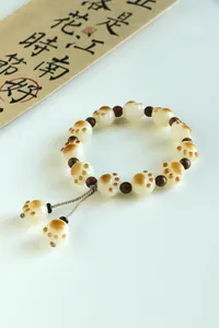 Detailed view of cat paw shaped Bodhi seed bracelet with decorative wood beads.
