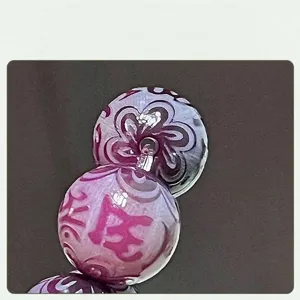 Close-up detail of Yuanshandai Bodhi beads with purple mantra and polished holes.