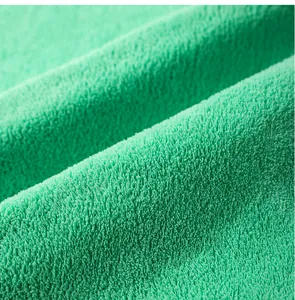Macro view of soft green coral fleece fabric texture for absorbent pet pee pad detail