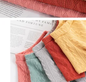Close-up detail of soft colorful knitted pet sweaters with textured cable patterns