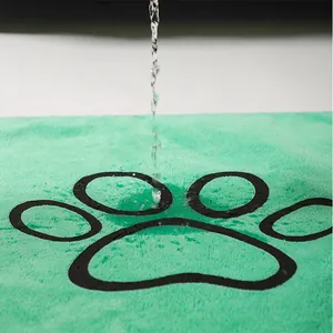 Close-up of green coral fleece pet mat showing water absorption and leak-proof detail