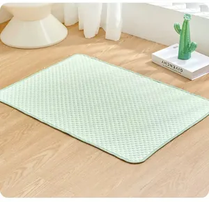 Light green summer pet cooling mat with breathable ice bean texture on a wooden floor
