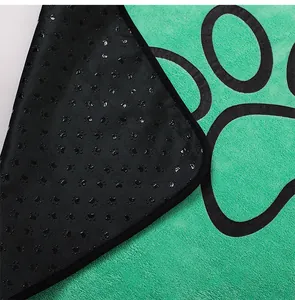 Macro detail of green coral fleece pet pee pad with non-slip paw print backing pattern