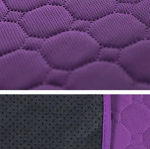 Macro view of purple quilted honeycomb fabric and non-slip backing of pet pee pad.