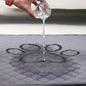 Agua vertida sobre un empapador lavable gris para perros para mostrar la absorpcion