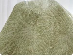 Close-up detail of sage green pet mat with leaf pattern jacquard fabric texture.