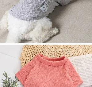 Detailed view of texture and cable-knit pattern on grey and coral pink pet sweaters