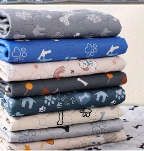 Detalle de una pila de empapadores lavables para mascotas con varios diseños y colores