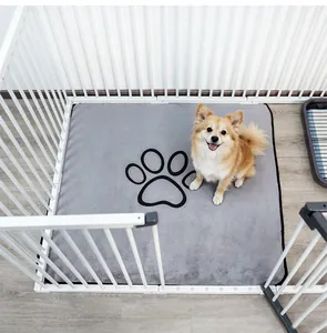 Reusable gray coral fleece pet pee pad with paw print shown in white fence cage context.