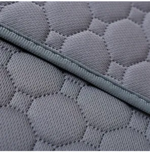 Primer plano de la textura de malla gris acolchada y las costuras de un tapete para mascotas