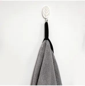 Soft grey coral fleece pet towel hanging on a white decorative leaf wall hook