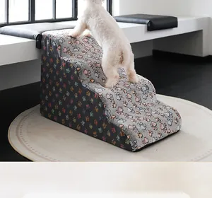 Action shot of a small dog climbing paw-patterned foam pet stairs next to a sofa.