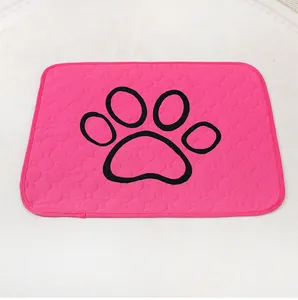 Primer plano de empapador lavable rosa para mascotas con estampado de pata negra.