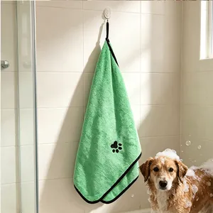 Green pet bath towel hanging in bathroom with soapy golden retriever dog