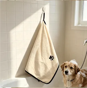 Soft absorbent coral fleece pet bath towel hanging by a bathtub with a golden retriever