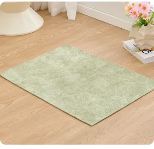 Close-up of a light green non-slip pet mat with textured floral pattern on a wooden floor.
