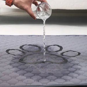 Alfombrilla absorbente gris para mascotas con huella probando la protección de fugas