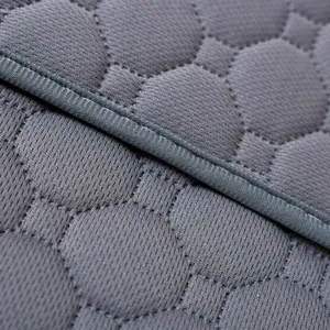 Detalle de empapador lavable gris con textura de nido de abeja y costuras de alta calidad