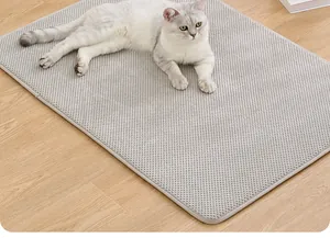 Gros plan d'un chat blanc se reposant sur un tapis gris antidérapant pour animaux de compagnie