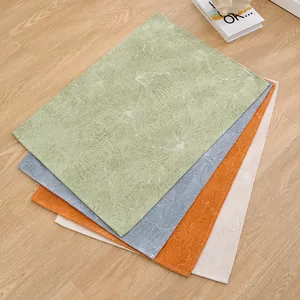 Four pieces of textured anti-slip pet mats in green, blue, orange, and beige on wood floor