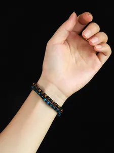 Vista detallada de pulseras de cuentas de ojo de tigre amarillo y azul de 4 mm en la muñeca