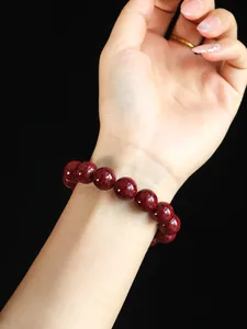 Detaillierte Makroansicht eines natürlichen roten Zinnober-Perlenarmbands am Handgelenk