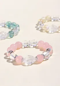 Detalle de pulsera de cuarzo rosa con cuentas de cristal y dije de tortuga dragón