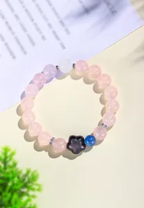 Vista detallada de la pulsera de cuentas de cuarzo rosa natural con un dije de flor de obsidiana.