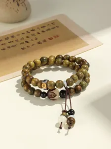 Close-up of double-strand green sandalwood beaded bracelet with lotus engraving