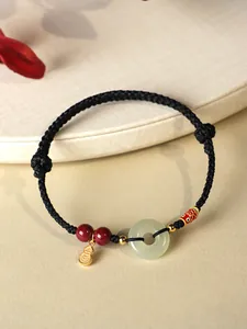 Vue détaillée d'un bracelet ethnique tressé main avec anneau en jade et breloques