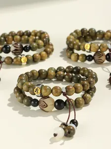 Detailed view of green sandalwood double-strand zodiac beads with engraved charm.