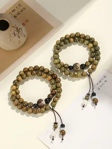 Detail shot of green sandalwood double-layer beaded bracelet with engraved charms