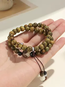 Detailed macro shot of green sandalwood beads and intricately carved central charm.