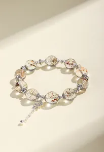 Detailansicht des 12mm Schwarz-Gold-Super-Sieben-Kristallarmbands mit Blattanhänger