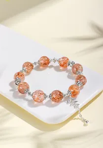 Detailansicht eines 12mm natürlichen Super Seven Kristallarmbands mit einem Blattanhänger