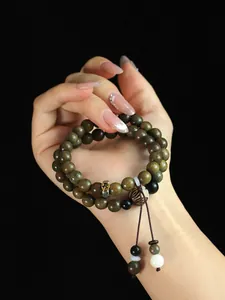Detailed view of natural green sandalwood double-strand beaded bracelet on hand.