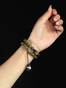 Detailed view of traditional green sandalwood double-strand bead bracelet on person wrist