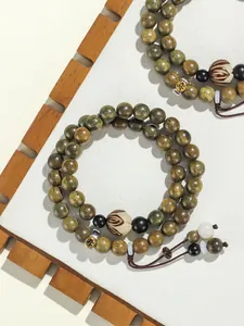 Detailed view of double-loop green sandalwood beaded bracelet with zodiac carvings