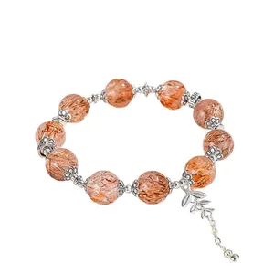 12-mm-Armband aus natürlichen Super-Seven-Kristallen mit Blattanhänger auf weißem Grund