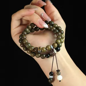 Handmade double-strand green sandalwood beaded bracelet with traditional protection charms.