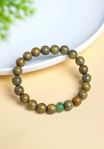 Close-up detail of a natural green sandalwood beaded bracelet featuring a green jade bead.