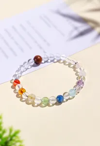 Primer plano de una pulsera de cuentas de cristal natural multicolor sobre fondo beige claro