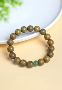 Close-up detail of a natural green sandalwood beaded bracelet with aventurine stone.