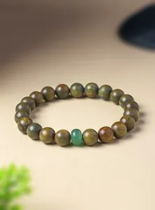 Close-up of natural green sandalwood beaded bracelet with a single green jade accent