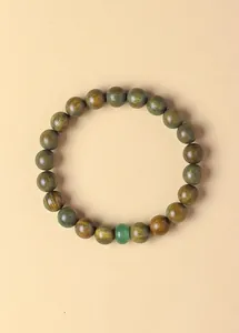 Detail view of natural green sandalwood beaded bracelet with a green aventurine stone.