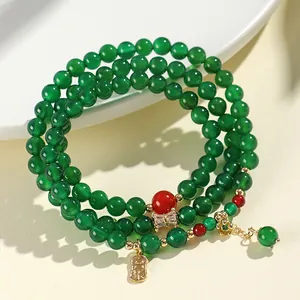 Ethnic style multi-layer bracelet with green and red agate beads and gold charm detail